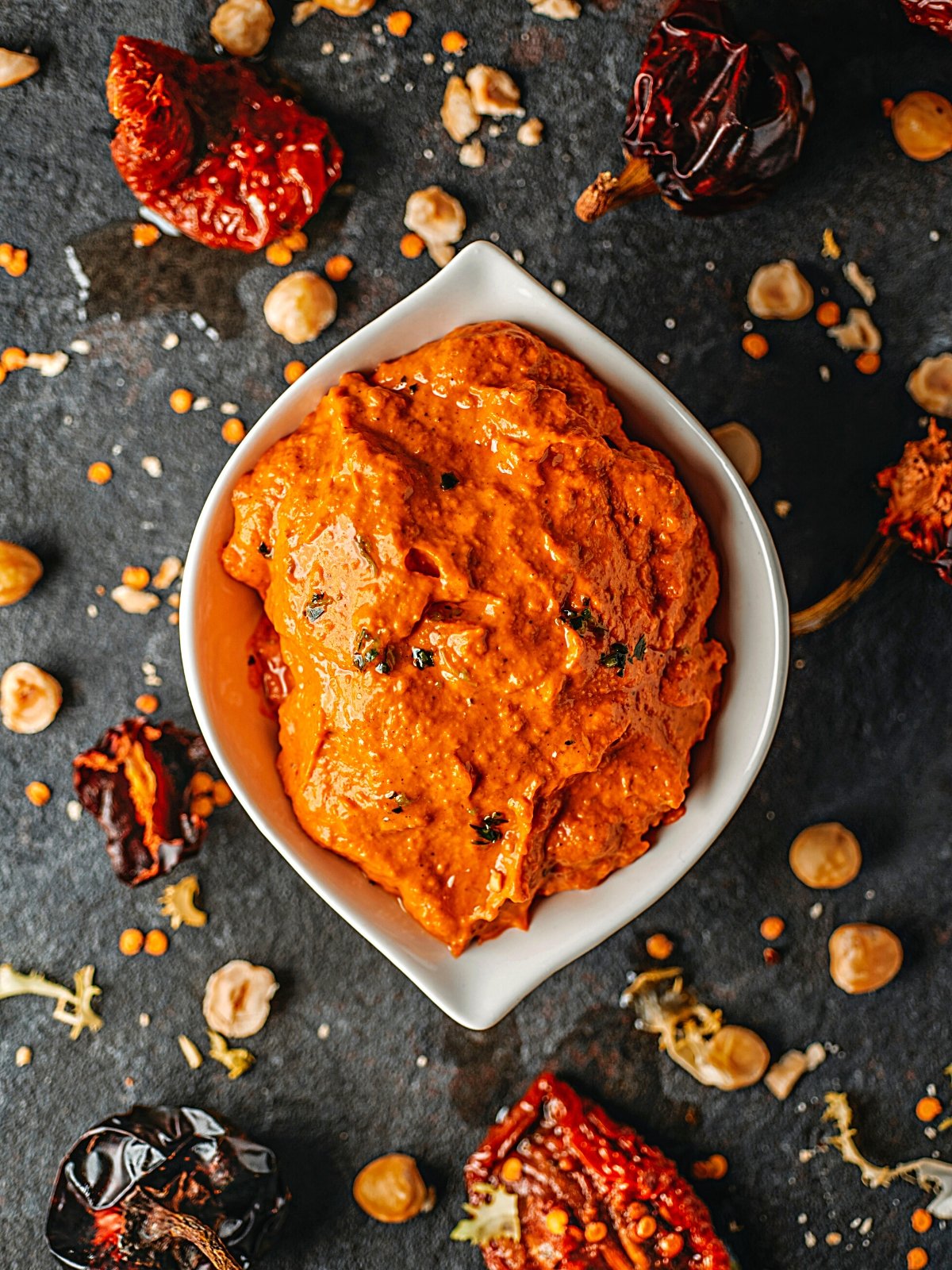 A bowl full of Romesco Sauce garnished with parsley.