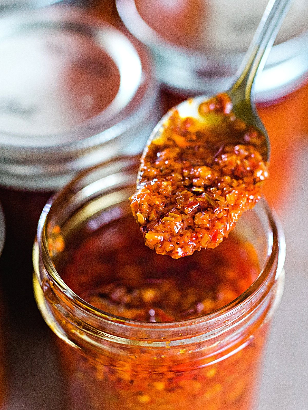 A spoon full of Calabrian Chili Paste from the glass jar.