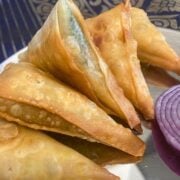 Hyderabadi onion samosas on metal platter.
