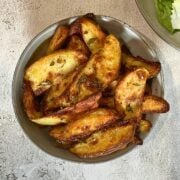 Baked and Seasoned potato wedges in a grey bowl.